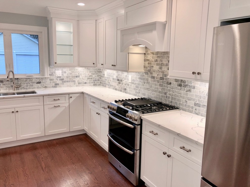 This is an example of a mid-sized transitional u-shaped separate kitchen in Other with an undermount sink, shaker cabinets, white cabinets, marble benchtops, grey splashback, stone tile splashback, stainless steel appliances, dark hardwood floors, no island, brown floor and white benchtop.