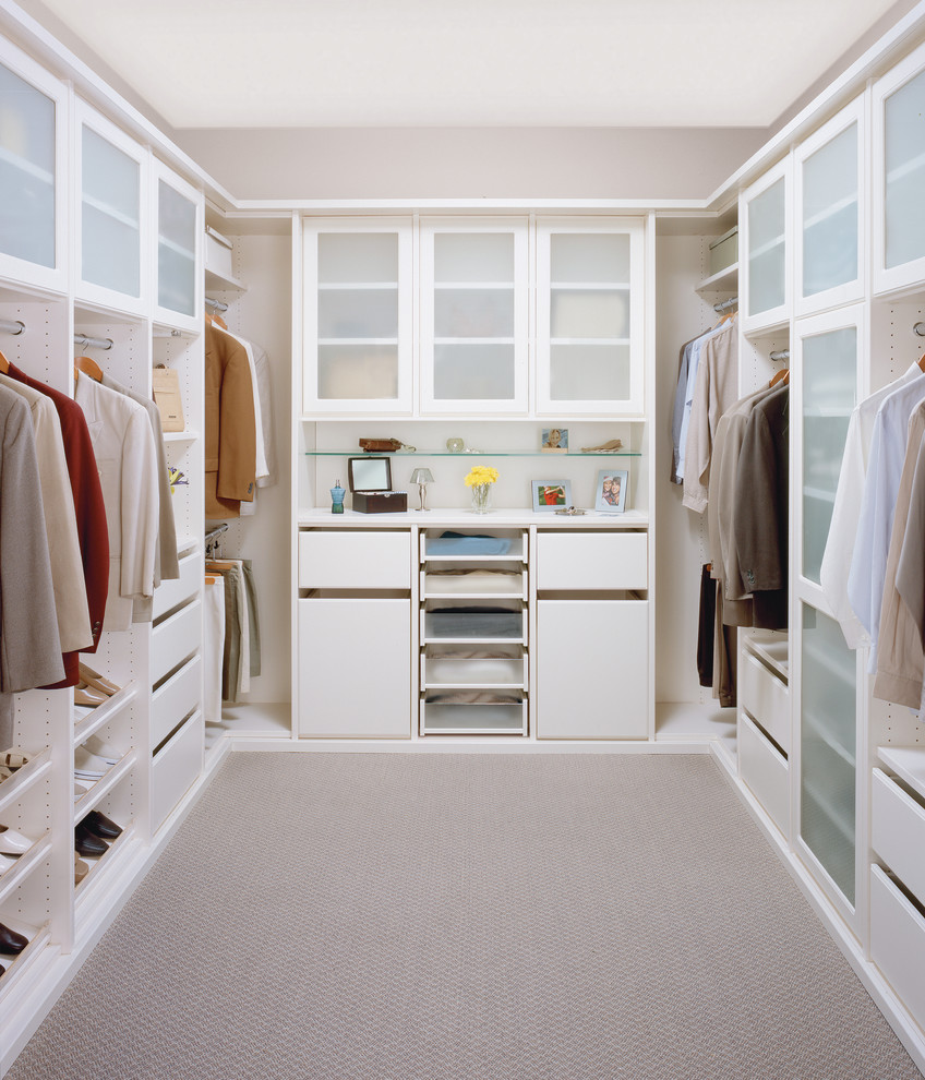 Photo of a small contemporary gender-neutral walk-in wardrobe in Los Angeles with white cabinets and carpet.
