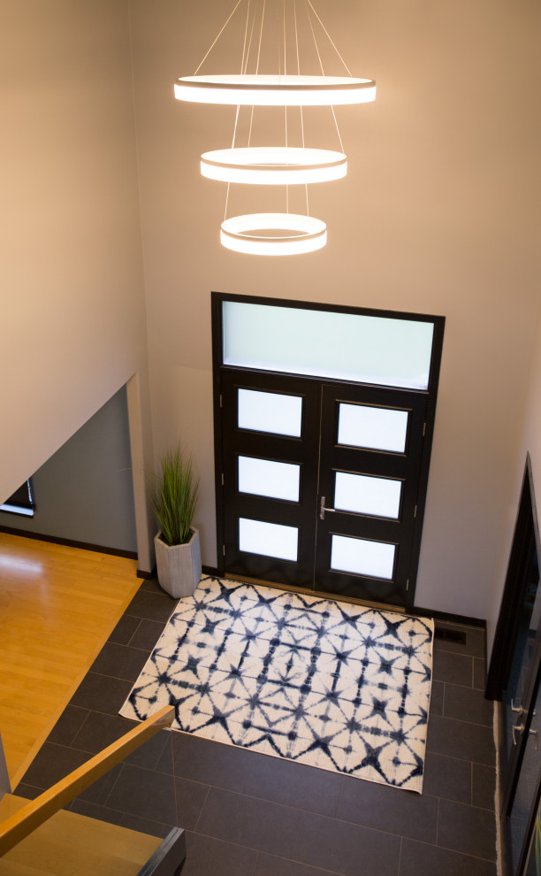 Пример оригинального дизайна: входная дверь среднего размера в стиле модернизм с бежевыми стенами, двустворчатой входной дверью, серой входной дверью, полом из сланца и коричневым полом