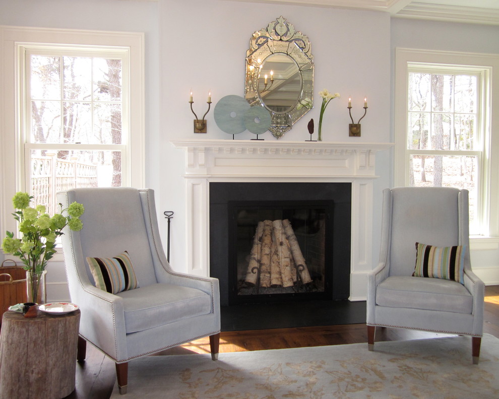 This is an example of a large transitional formal open concept living room in New York with white walls, medium hardwood floors, a standard fireplace and a wood fireplace surround.