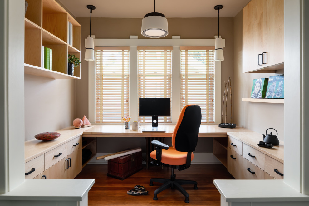 Réalisation d'un petit bureau design de type studio avec un mur beige, un sol en bois brun, aucune cheminée, un bureau intégré, un sol marron et différents designs de plafond.