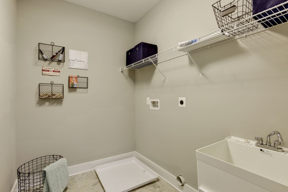 Photo of a small country single-wall dedicated laundry room in Baltimore with an utility sink, grey walls, laminate floors and a side-by-side washer and dryer.