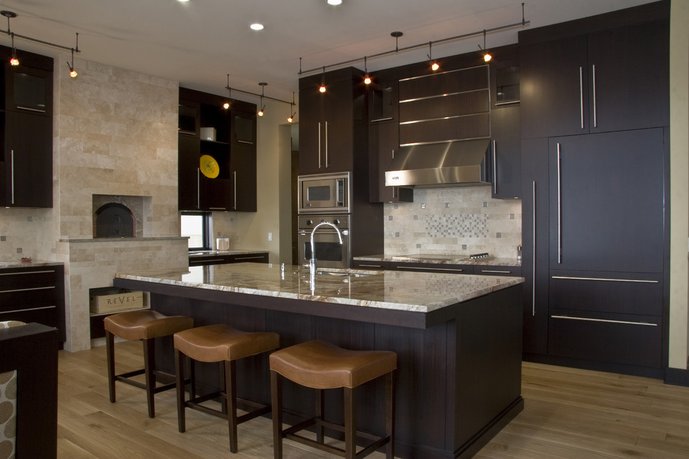 This is an example of a contemporary kitchen in Grand Rapids with panelled appliances and limestone splashback.