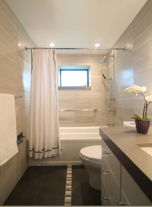 Small contemporary ensuite bathroom in Other with flat-panel cabinets, light wood cabinets, a built-in bath, a two-piece toilet, stone slabs, porcelain flooring, a submerged sink and engineered stone worktops.