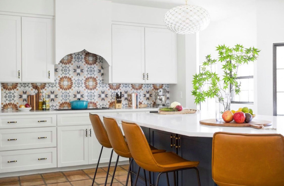 Mid-sized contemporary eat-in kitchen in Los Angeles with shaker cabinets, white cabinets, quartz benchtops, multi-coloured splashback, ceramic splashback, terra-cotta floors, with island, beige floor and white benchtop.