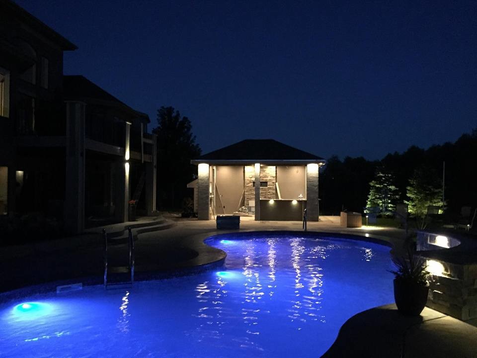 Example of a mid-sized trendy backyard stamped concrete and kidney-shaped pool house design