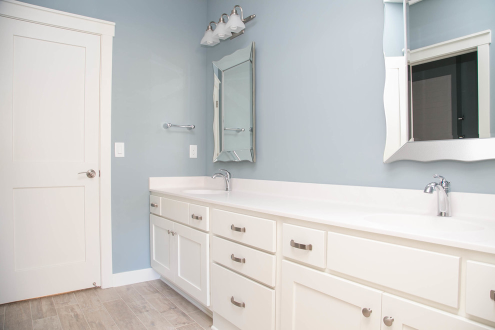 Inspiration for a transitional 3/4 bathroom in Minneapolis with shaker cabinets, white cabinets, an alcove shower, a one-piece toilet, beige tile, grey walls, ceramic floors, an undermount sink and marble benchtops.
