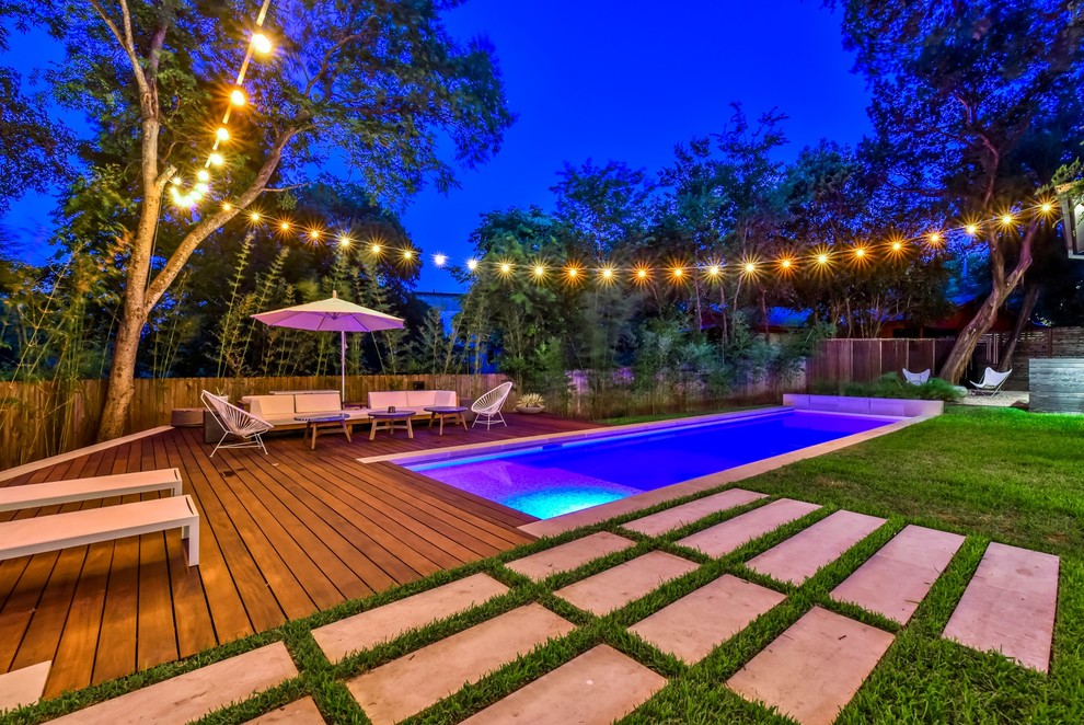 This is an example of a contemporary rectangular pool in Austin with decking.