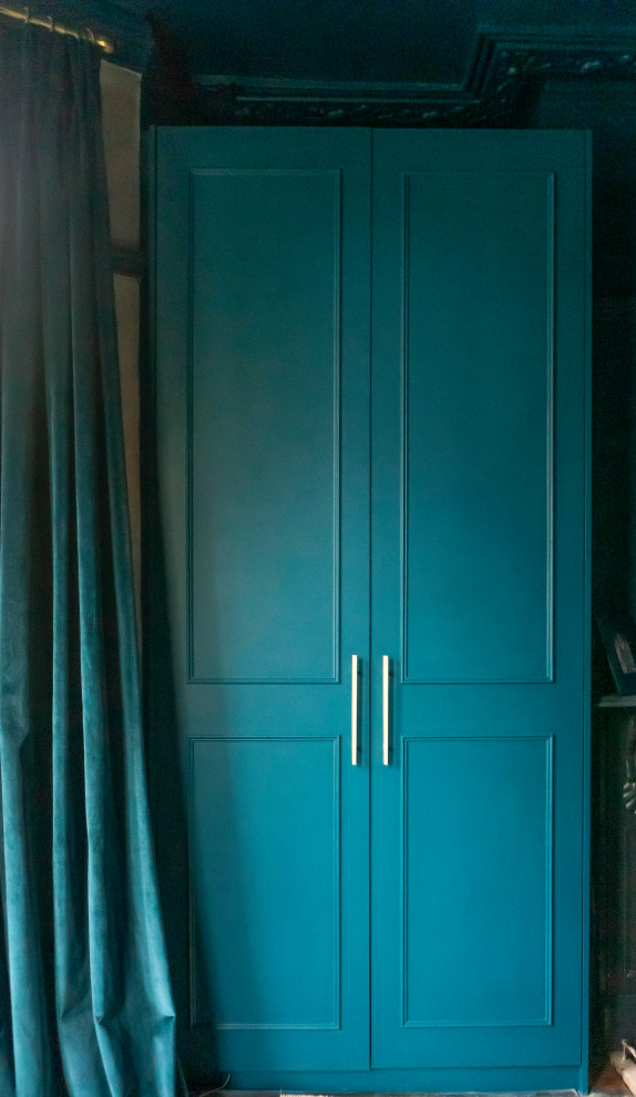 Réalisation d'une grande chambre parentale design avec un mur bleu, un manteau de cheminée en bois, parquet foncé, un sol marron et du papier peint.