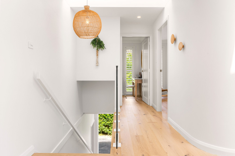 Großer Moderner Flur mit weißer Wandfarbe, hellem Holzboden und beigem Boden in Sydney