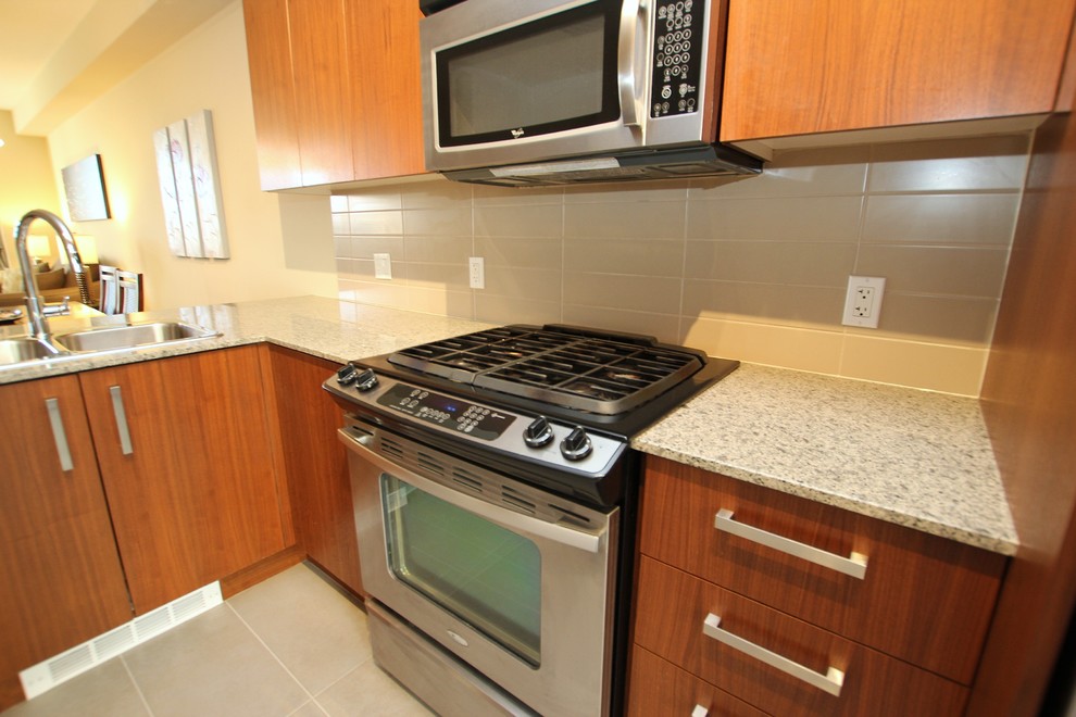 Contemporary eat-in kitchen in Vancouver with granite benchtops and stainless steel appliances.