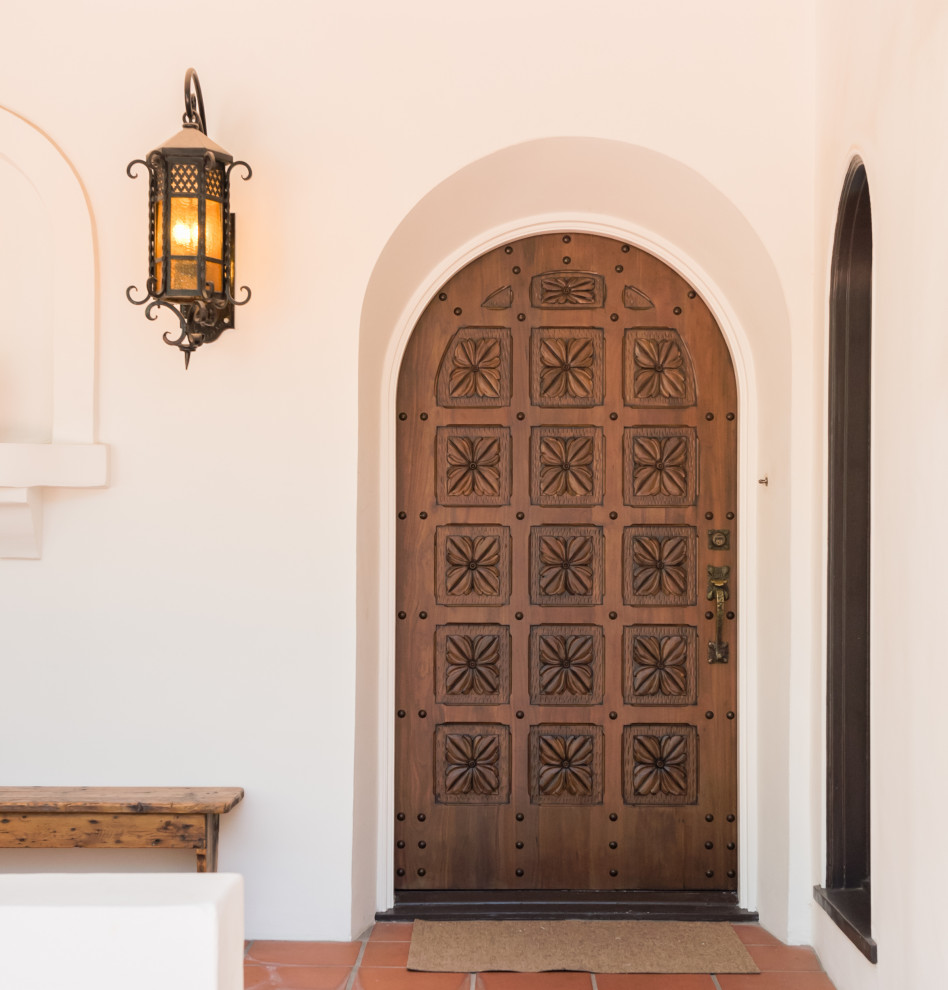 Design ideas for a mediterranean front door in Tampa with a single front door and a dark wood front door.