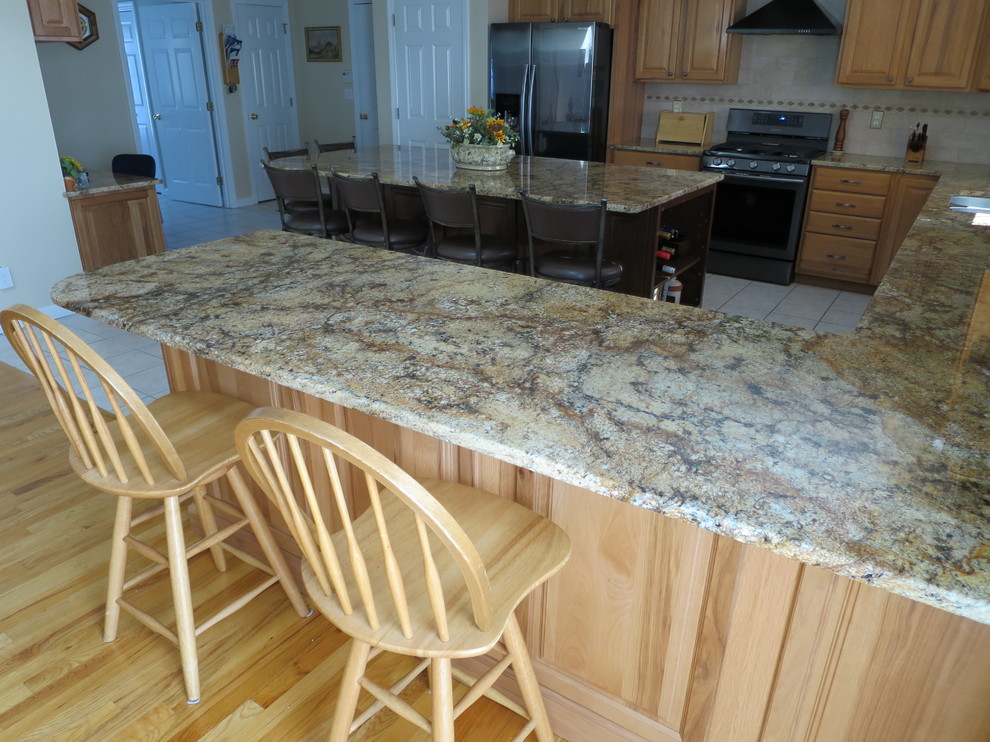 Example of a mid-sized transitional u-shaped ceramic tile and white floor eat-in kitchen design in Bridgeport with a double-bowl sink, raised-panel cabinets, light wood cabinets, granite countertops, white backsplash, subway tile backsplash, stainless steel appliances and an island