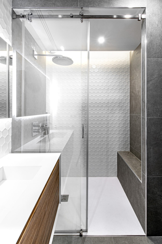 This is an example of a mid-sized contemporary 3/4 bathroom in Nice with flat-panel cabinets, medium wood cabinets, an alcove shower, gray tile, an integrated sink, grey floor, a sliding shower screen and white benchtops.