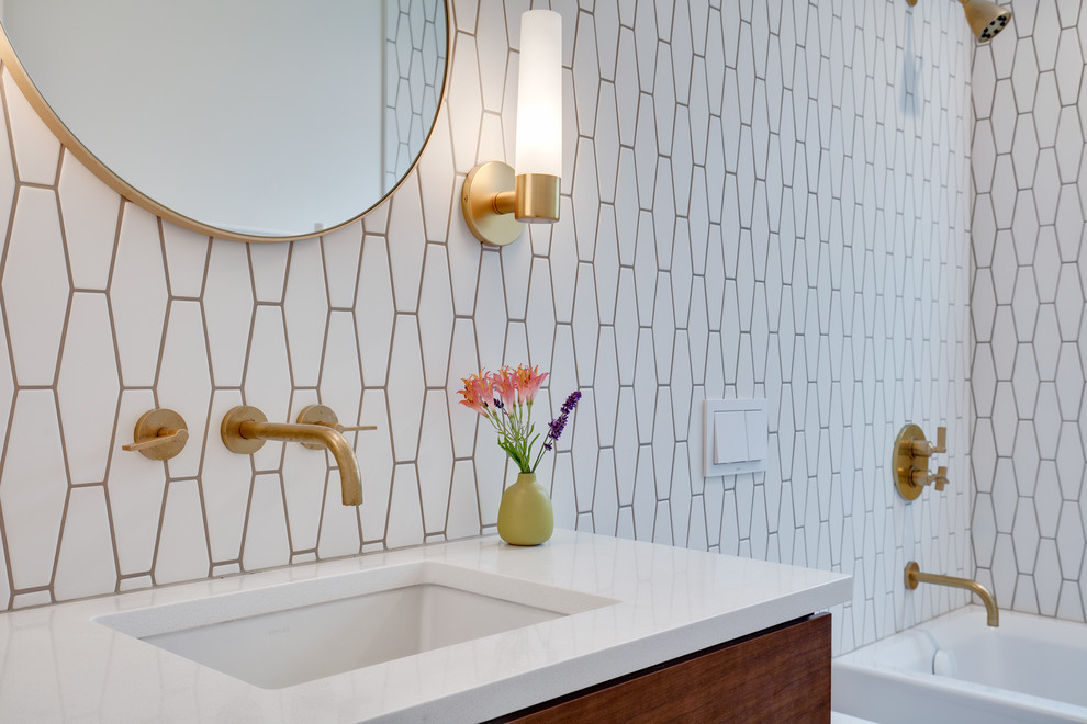 Mid-sized modern bathroom in Seattle with flat-panel cabinets, medium wood cabinets, a drop-in tub, a shower/bathtub combo, a one-piece toilet, white tile, cement tile, white walls, ceramic floors, a drop-in sink, quartzite benchtops, white floor, a shower curtain and white benchtops.
