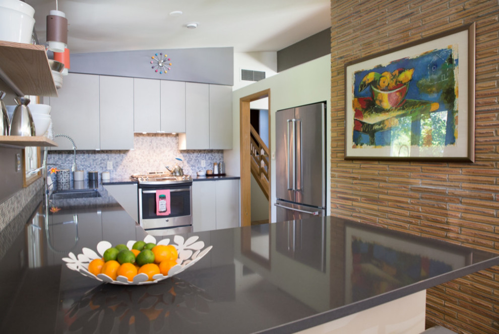 Foto di una cucina ad U moderna chiusa e di medie dimensioni con lavello sottopiano, ante lisce, ante grigie, top in granito, elettrodomestici in acciaio inossidabile e top nero