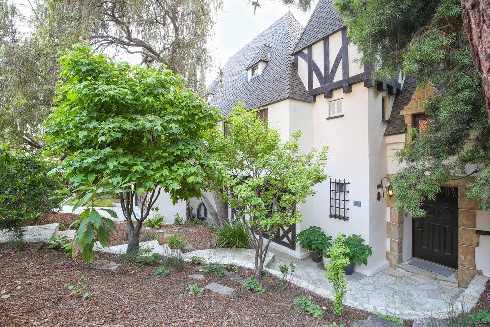 Inspiration for a mid-sized traditional two-storey stucco beige exterior in Los Angeles with a clipped gable roof.