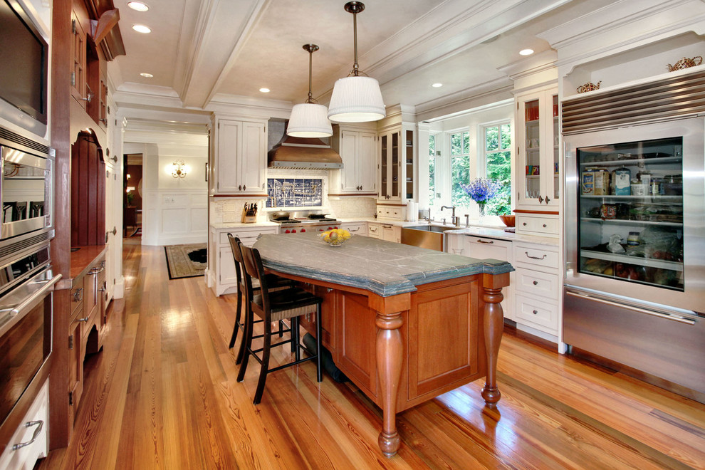 Inspiration for a traditional kitchen in New York with white cabinets, white splashback and stainless steel appliances.