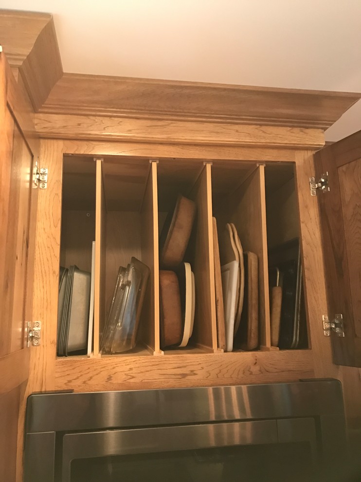 Eat-in kitchen - large rustic l-shaped light wood floor and beige floor eat-in kitchen idea with an undermount sink, raised-panel cabinets, medium tone wood cabinets, granite countertops, gray backsplash, ceramic backsplash, stainless steel appliances and an island