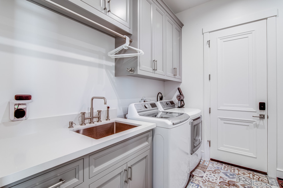 Large transitional galley utility room in San Francisco with an undermount sink, grey cabinets, quartz benchtops, grey walls, light hardwood floors, a side-by-side washer and dryer, white floor and white benchtop.
