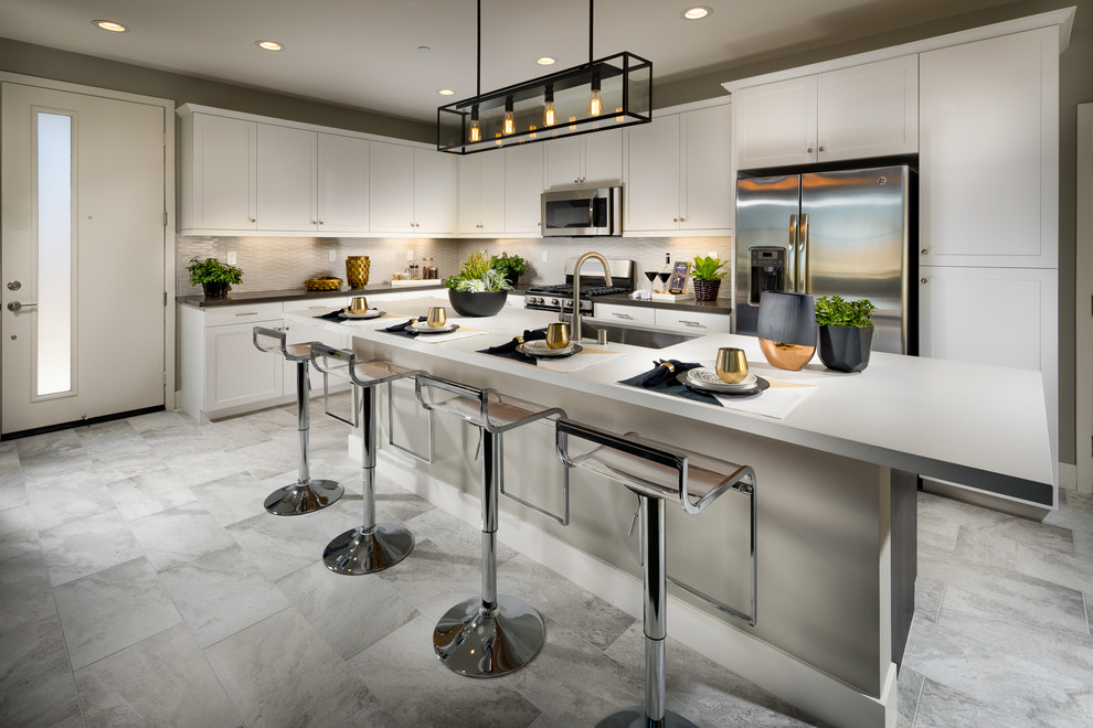 Design ideas for a contemporary l-shaped kitchen in San Diego with an undermount sink, shaker cabinets, grey cabinets, grey splashback, stainless steel appliances, with island, grey floor and black benchtop.