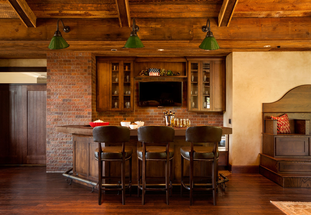 Photo of a country u-shaped seated home bar in Portland with shaker cabinets, dark wood cabinets, wood benchtops, dark hardwood floors and brown benchtop.