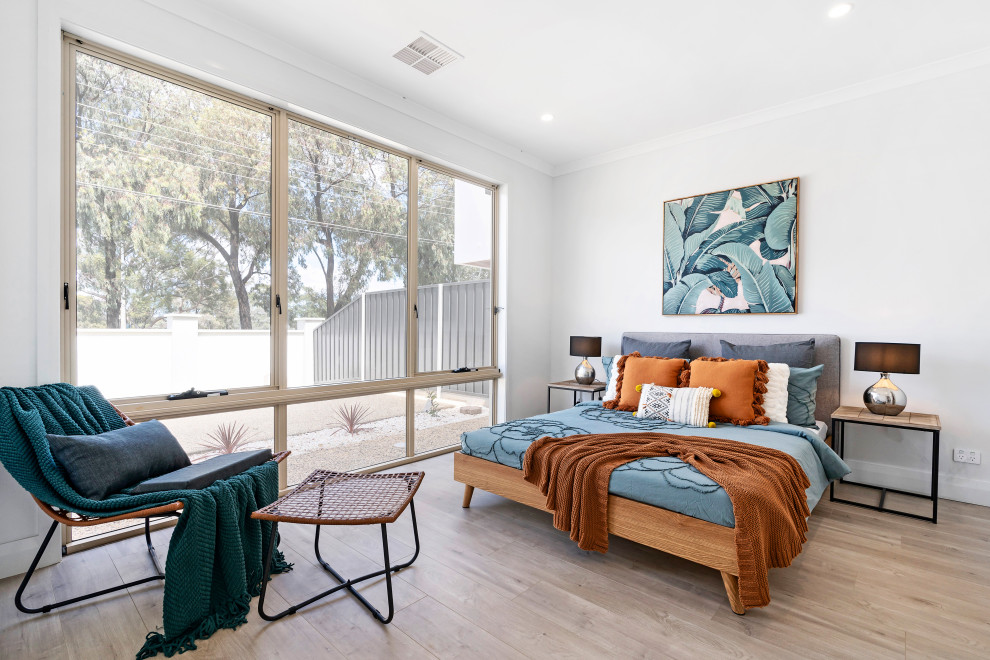 This is an example of a contemporary bedroom in Adelaide with white walls, light hardwood floors and beige floor.