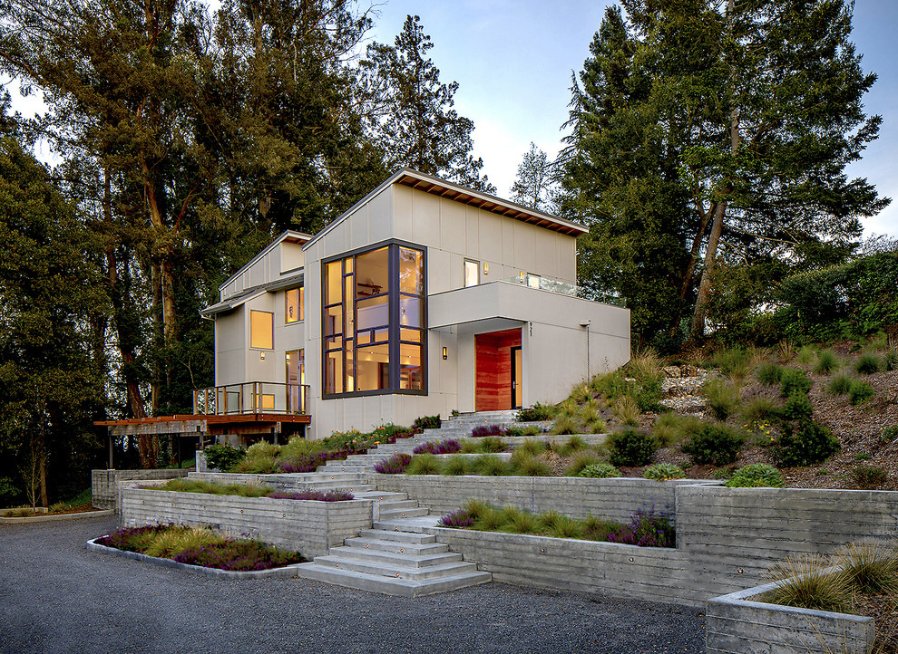 Mid-sized contemporary two-storey grey house exterior in San Francisco with concrete fiberboard siding, a shed roof and a shingle roof.