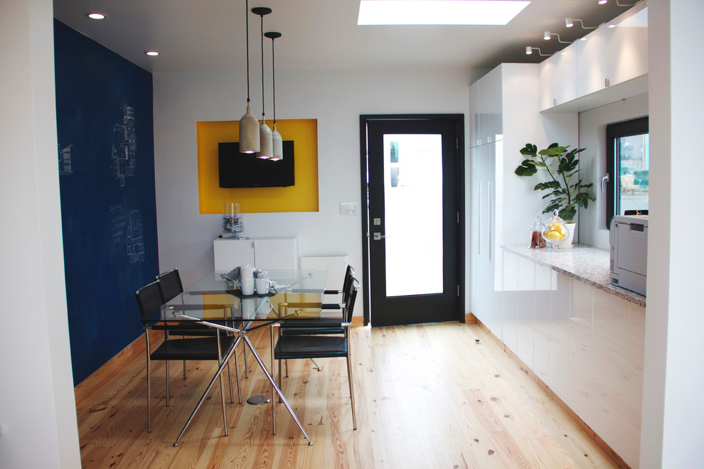 This is an example of a small modern dining room in Portland with blue walls and light hardwood floors.