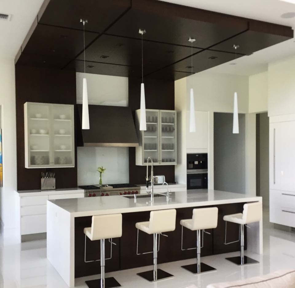 Photo of a mid-sized modern l-shaped open plan kitchen in Other with solid surface benchtops, an undermount sink, flat-panel cabinets, white cabinets, brown splashback, stone slab splashback, stainless steel appliances, porcelain floors, with island, white floor and white benchtop.