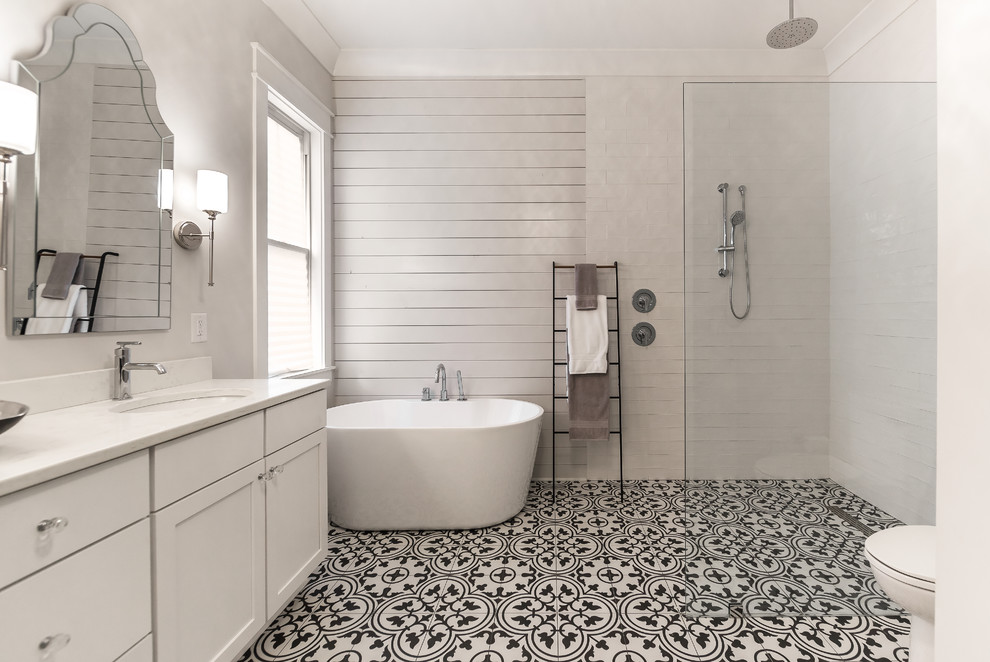 Design ideas for a mid-sized country master bathroom in Atlanta with recessed-panel cabinets, white cabinets, a freestanding tub, an open shower, a two-piece toilet, yellow tile, porcelain tile, white walls, porcelain floors, an undermount sink, engineered quartz benchtops, multi-coloured floor, an open shower and white benchtops.
