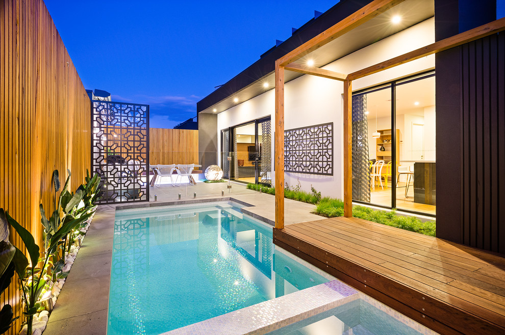 Inspiration for a contemporary side yard custom-shaped lap pool in Melbourne with a hot tub and concrete pavers.