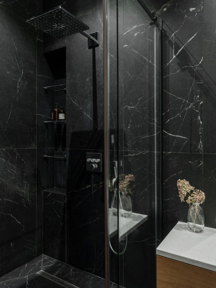 Свежая идея для дизайна: ванная комната среднего размера в современном стиле с плоскими фасадами, фасадами цвета дерева среднего тона, душем в нише, инсталляцией, черной плиткой, керамогранитной плиткой, черными стенами, полом из керамогранита, душевой кабиной, накладной раковиной, столешницей из искусственного камня, черным полом, душем с раздвижными дверями, бежевой столешницей, зеркалом с подсветкой, тумбой под одну раковину и подвесной тумбой - отличное фото интерьера