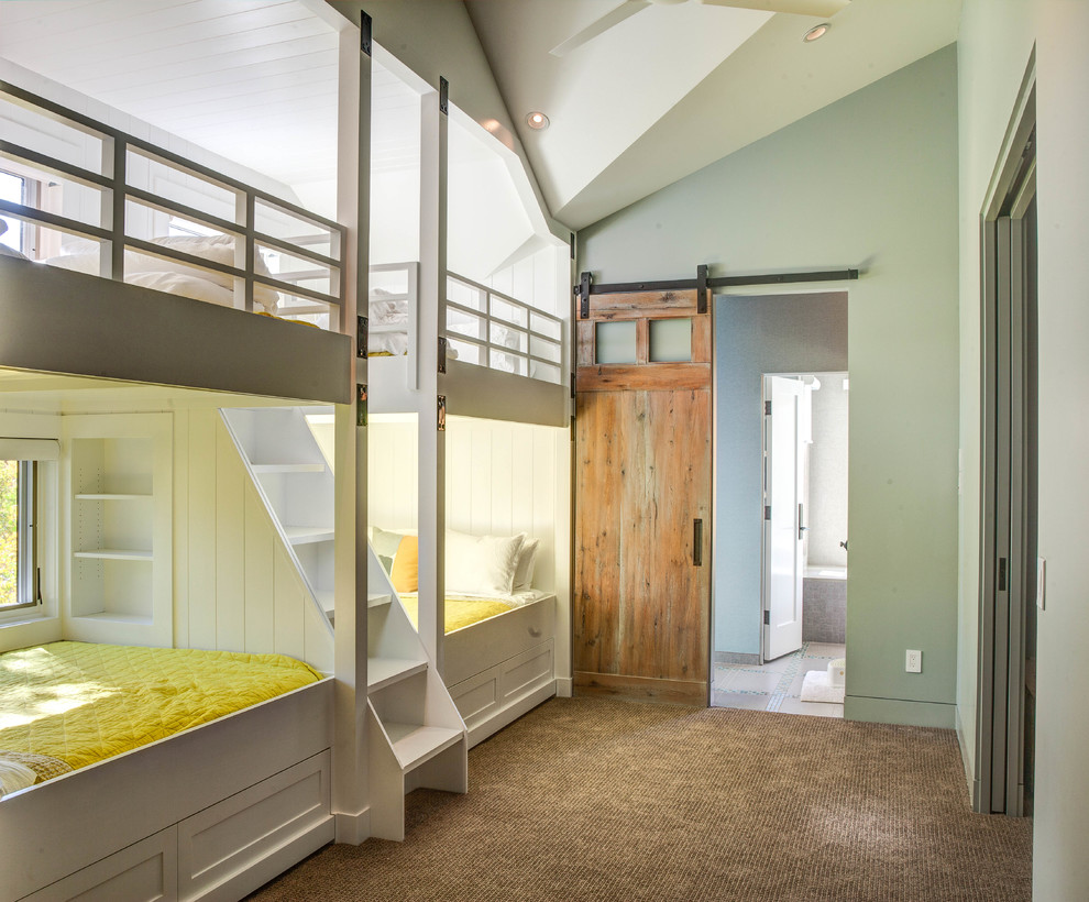 This is an example of a country gender-neutral kids' bedroom in Denver with green walls and carpet.