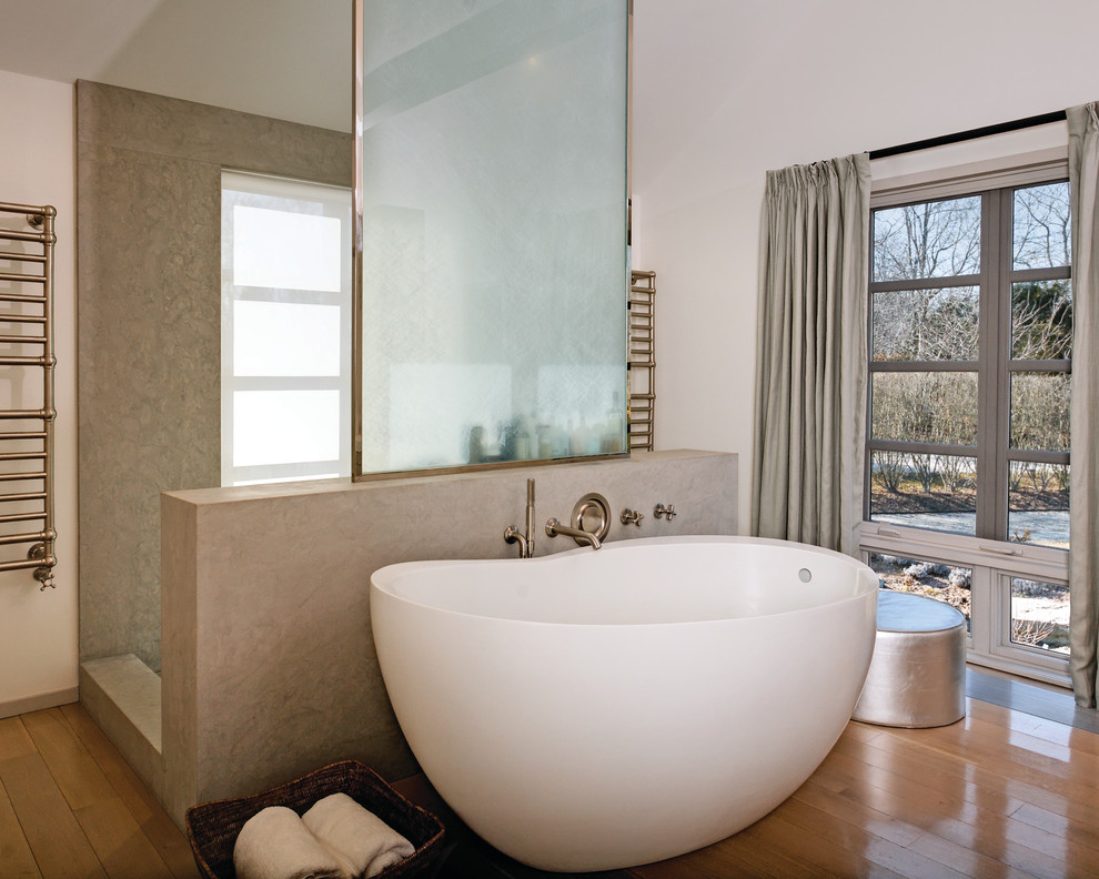 Photo of a contemporary bathroom in New York with a freestanding tub, an open shower, beige tile and an open shower.