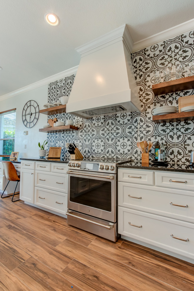 Inspiration for a large transitional l-shaped ceramic tile and brown floor eat-in kitchen remodel with an undermount sink, shaker cabinets, white cabinets, quartz countertops, multicolored backsplash, ceramic backsplash, stainless steel appliances, an island and white countertops