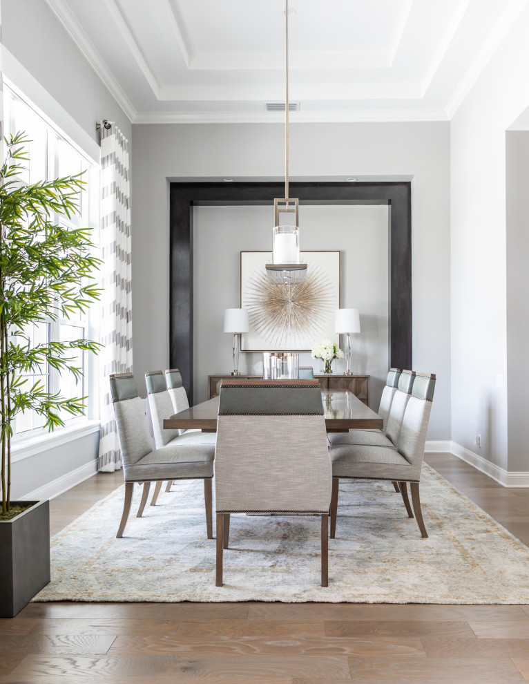 Photo of a transitional dining room in Jacksonville with grey walls, medium hardwood floors, brown floor and recessed.