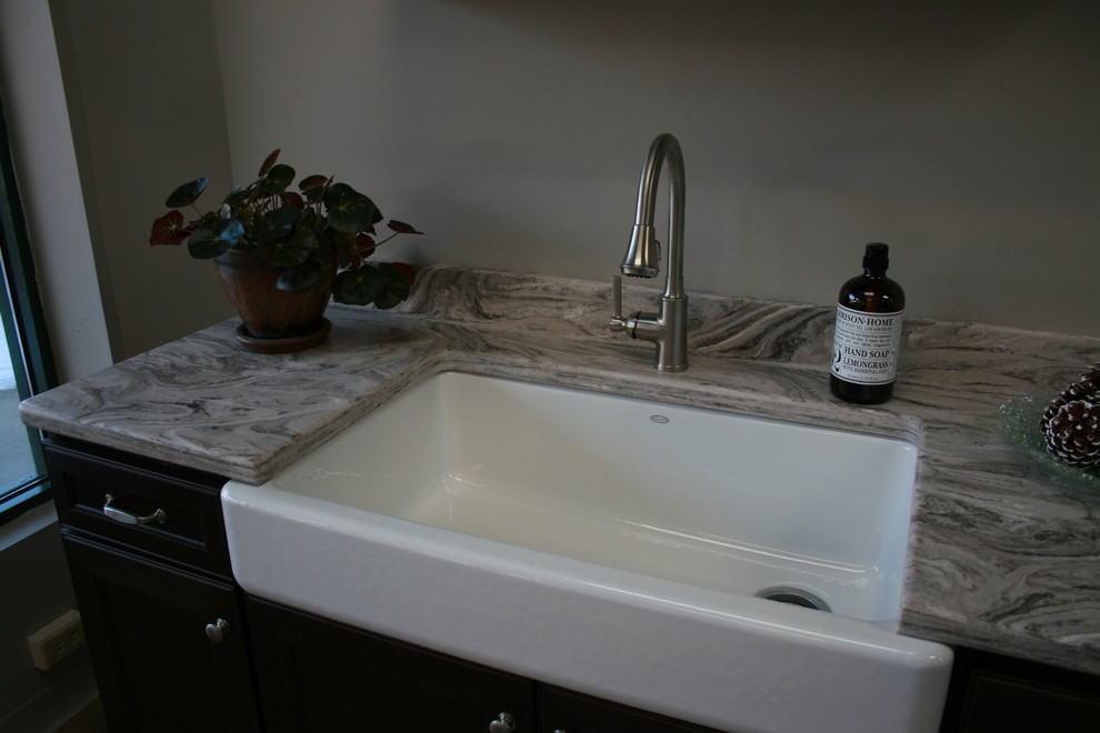 This is an example of a transitional laundry room in Other with a farmhouse sink.