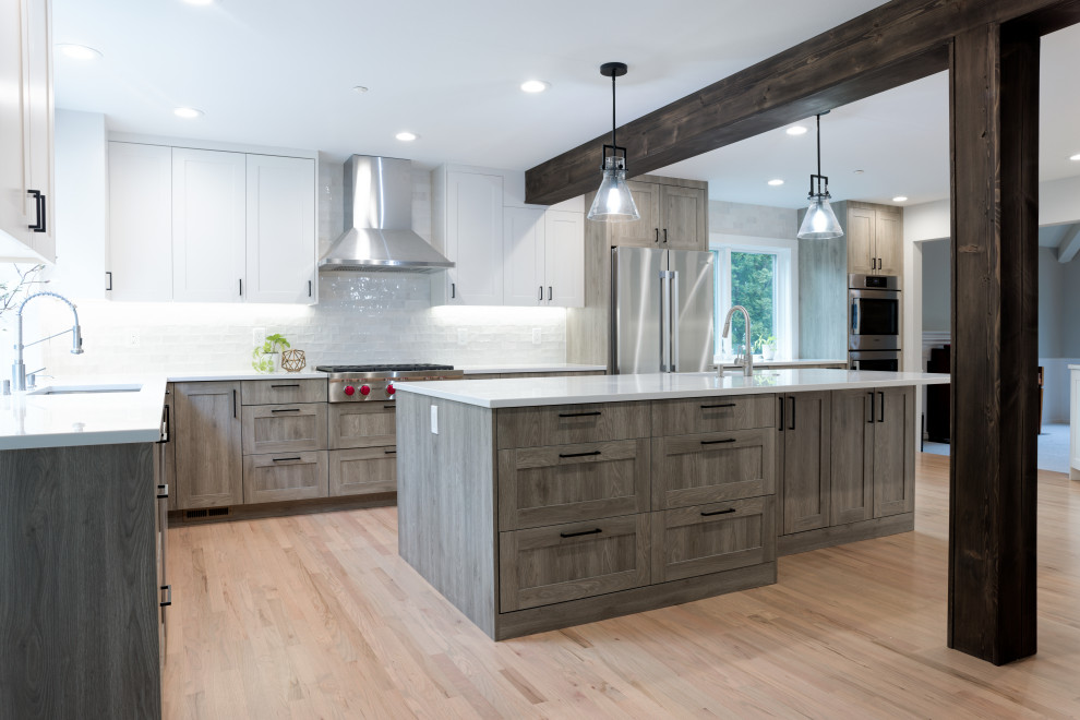 Large transitional l-shaped light wood floor, beige floor and exposed beam eat-in kitchen photo in Seattle with a single-bowl sink, shaker cabinets, medium tone wood cabinets, quartz countertops, white backsplash, ceramic backsplash, stainless steel appliances, an island and white countertops
