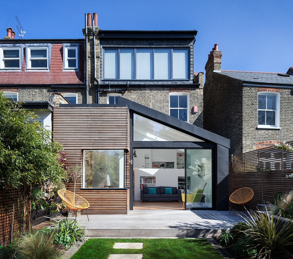 Mid-sized contemporary three-storey multi-coloured duplex exterior in London with mixed siding, a shed roof and a metal roof.