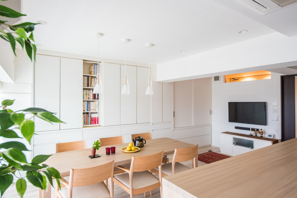 Inspiration for a mid-sized contemporary open plan dining in Tokyo with white walls, laminate floors and beige floor.