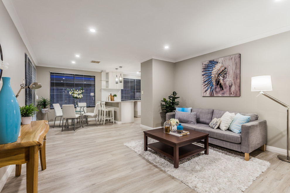 This is an example of a transitional open concept living room in Perth with grey walls and light hardwood floors.