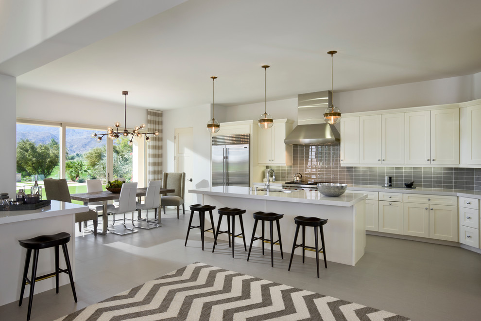Transitional l-shaped open plan kitchen in Orange County with shaker cabinets, white cabinets, grey splashback, subway tile splashback, stainless steel appliances and with island.