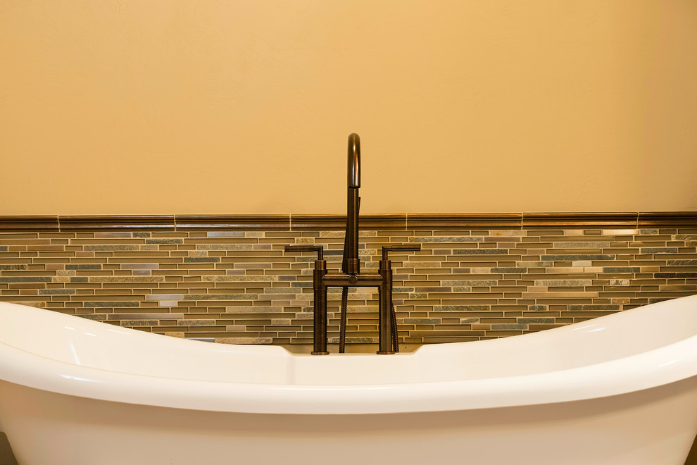 Large transitional master bathroom in Other with a freestanding tub, multi-coloured tile, glass tile and beige walls.