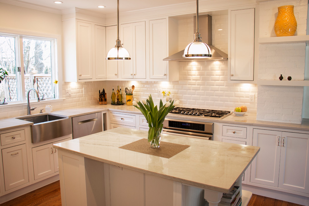 Small transitional l-shaped separate kitchen in New York with a farmhouse sink, beaded inset cabinets, white cabinets, quartzite benchtops, white splashback, subway tile splashback, stainless steel appliances, medium hardwood floors, with island and brown floor.