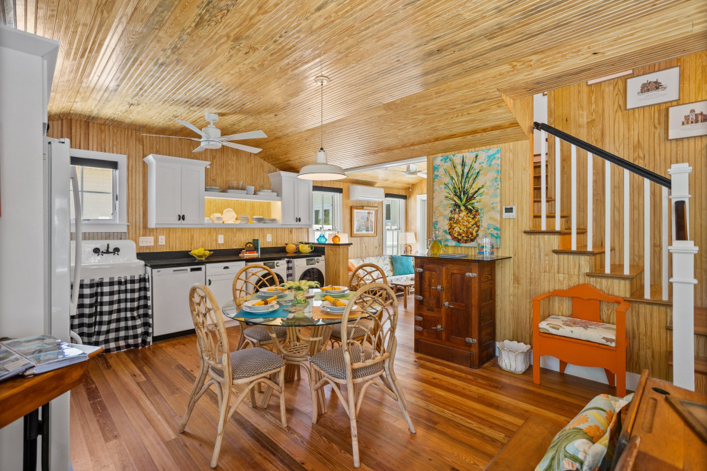 Kleine Maritime Wohnküche ohne Kamin mit brauner Wandfarbe, dunklem Holzboden, braunem Boden, Holzdecke und Holzwänden in Tampa