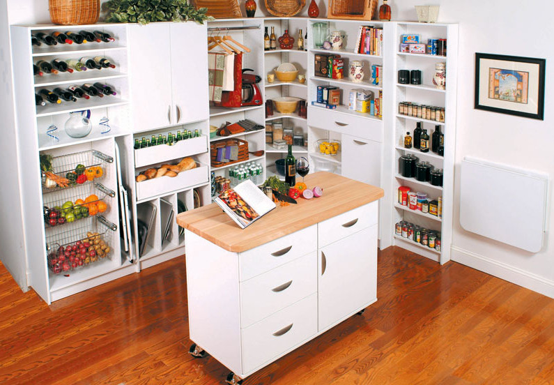 Inspiration for a large traditional l-shaped kitchen pantry in New York with flat-panel cabinets, white cabinets, wood benchtops, medium hardwood floors and with island.