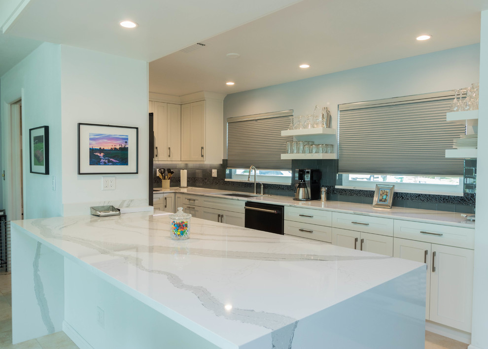 Open concept kitchen - mid-sized transitional galley ceramic tile open concept kitchen idea in Miami with a single-bowl sink, shaker cabinets, white cabinets, quartz countertops, black backsplash, glass tile backsplash, black appliances and a peninsula
