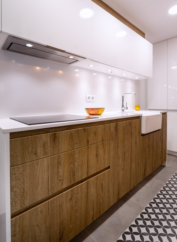 Design ideas for a contemporary galley enclosed kitchen in Barcelona with a single-bowl sink, medium wood cabinets, white splashback, stainless steel appliances, no island, white worktops and a drop ceiling.