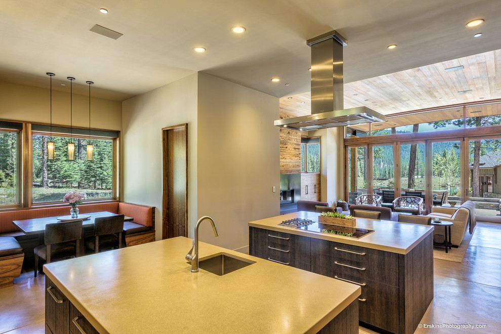 Design ideas for a large contemporary u-shaped eat-in kitchen in Sacramento with a drop-in sink, flat-panel cabinets, dark wood cabinets, concrete benchtops, beige splashback, metal splashback, stainless steel appliances, concrete floors and multiple islands.